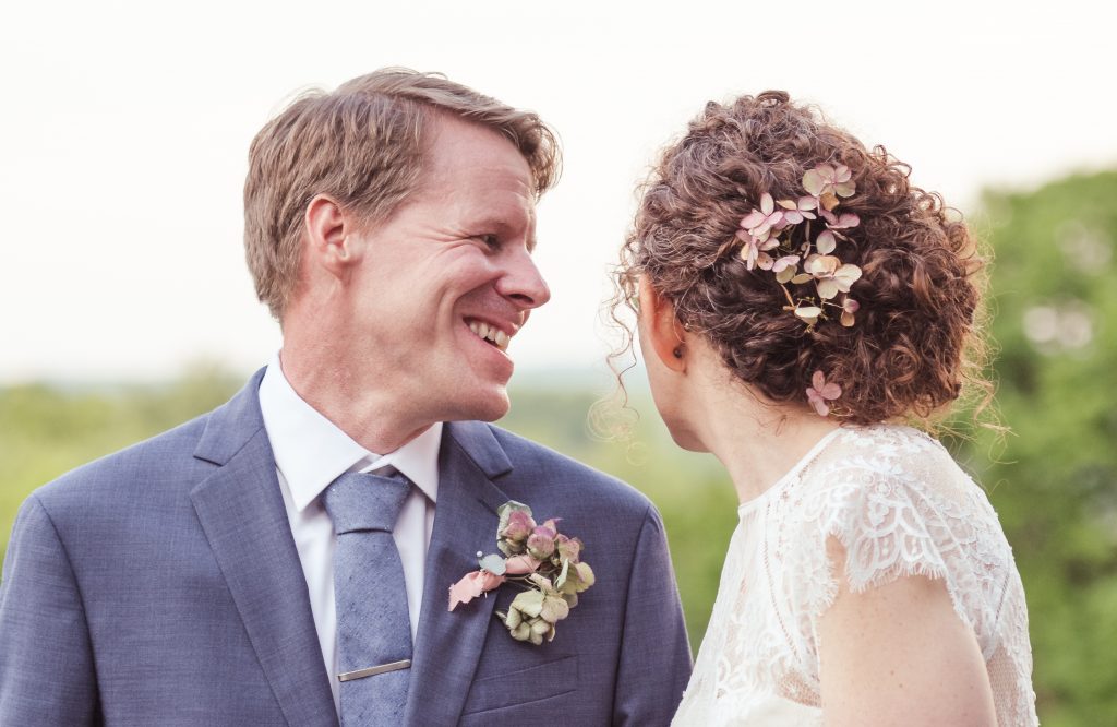 naturally curly wedding updo with flowers in her hair