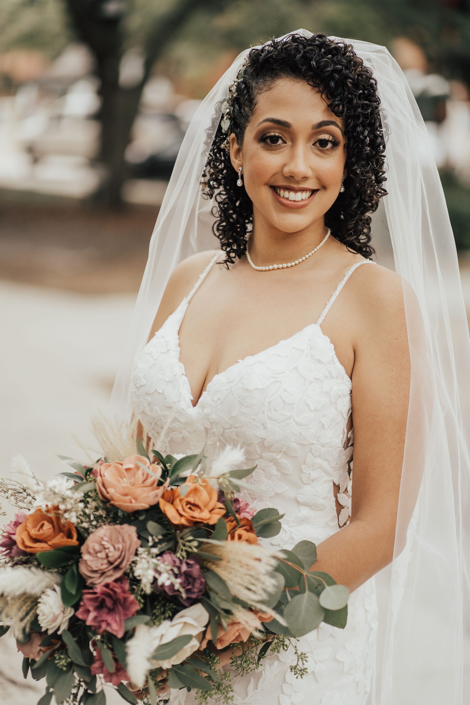 curly bridal style with a decorative command a veil