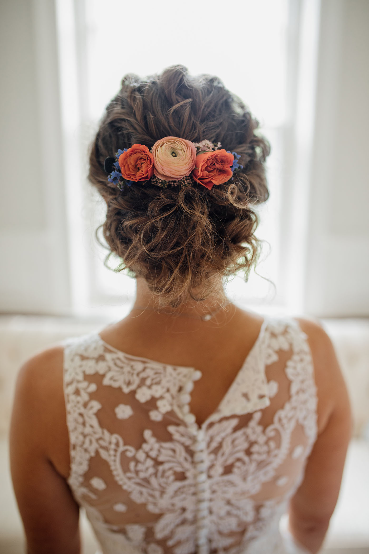 curly bridal low bun updo with flowers